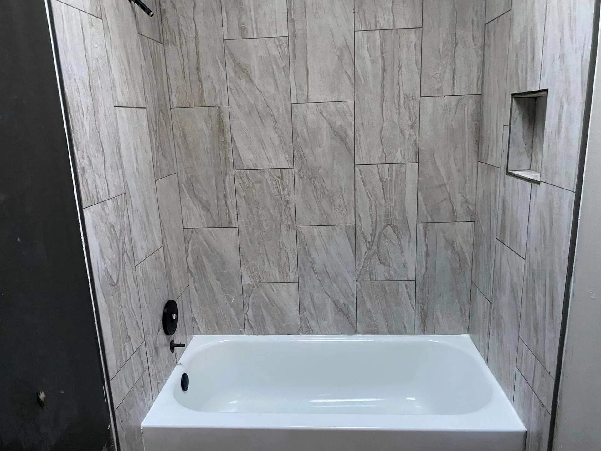 Tub with a large gray tile surround