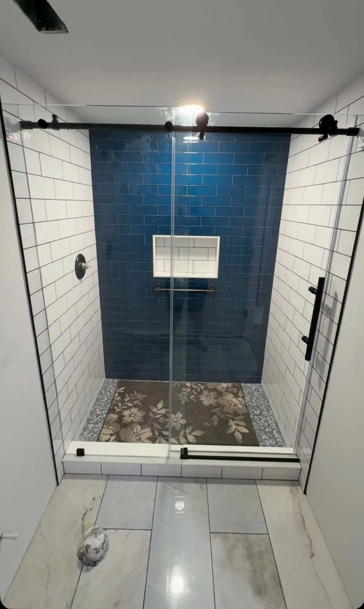 Shower with blue tile and a niche