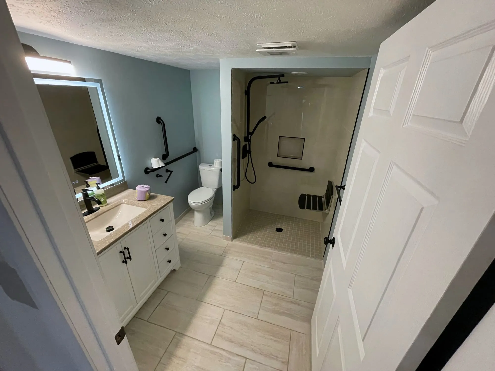 Accessible bathroom with a curbless shower, grab bars and new vanity