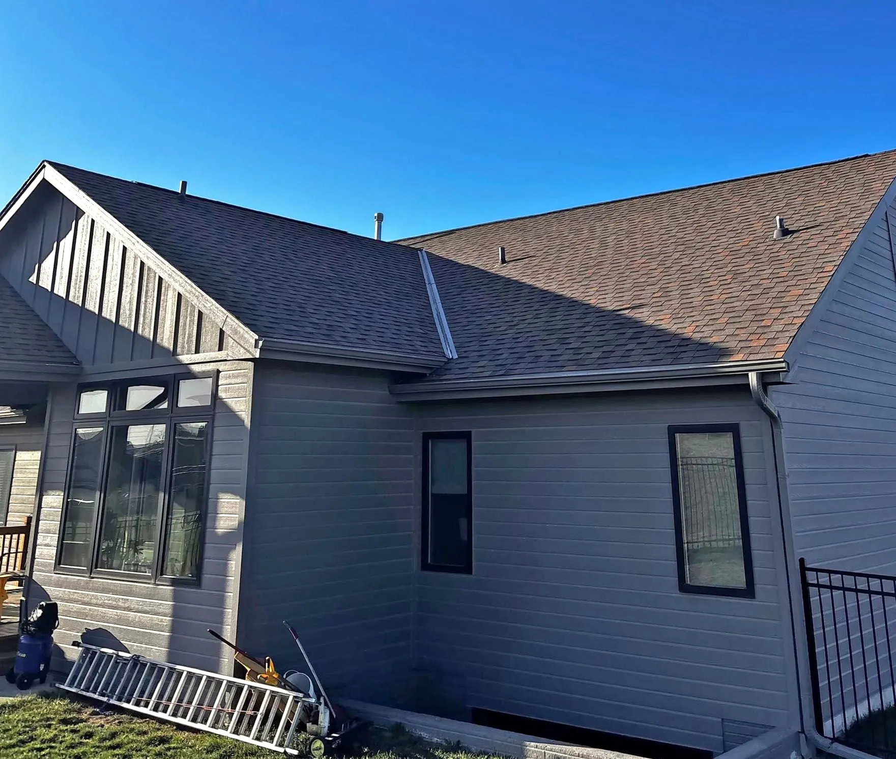 New roof and dark board-and-batten siding on the back of a house